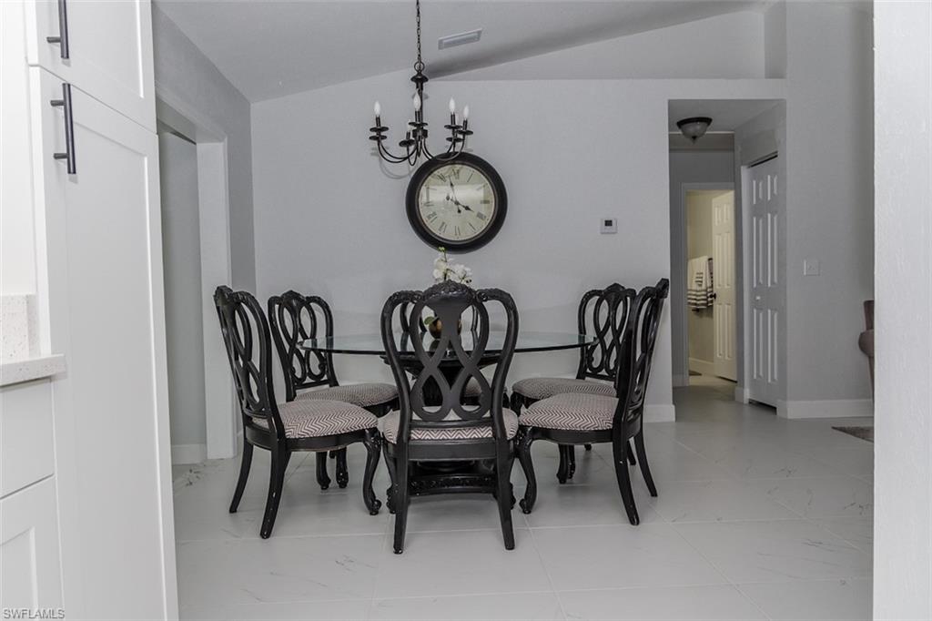131 22nd Street Northeast Naples, FL 34120 - Photo 11 of 34 a view of a dining room and livingroom with furniture a rug and a clock