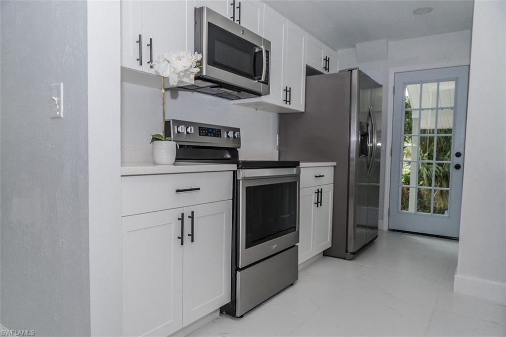 131 22nd Street Northeast Naples, FL 34120 - Photo 16 of 34 a kitchen with stainless steel appliances a stove microwave and refrigerator