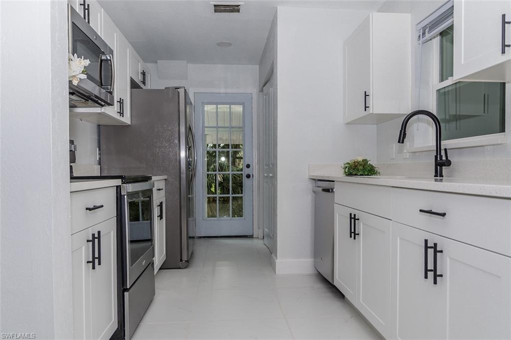 131 22nd Street Northeast Naples, FL 34120 - Photo 18 of 34 a kitchen with stainless steel appliances a sink stove and refrigerator