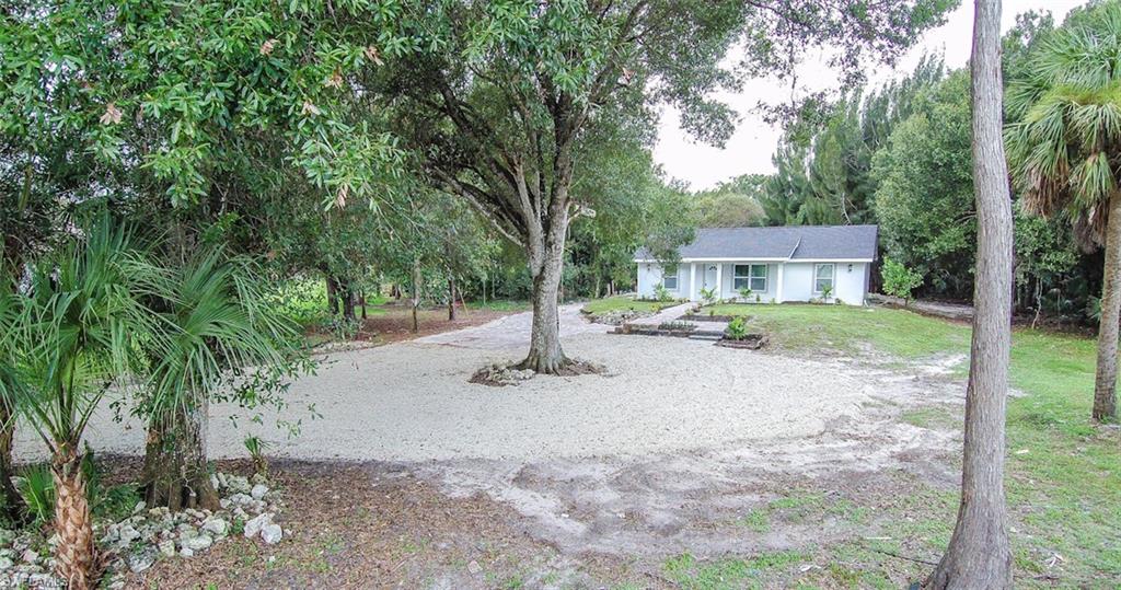 131 22nd Street Northeast Naples, FL 34120 - Photo 2 of 34 a backyard of a house with garden and patio