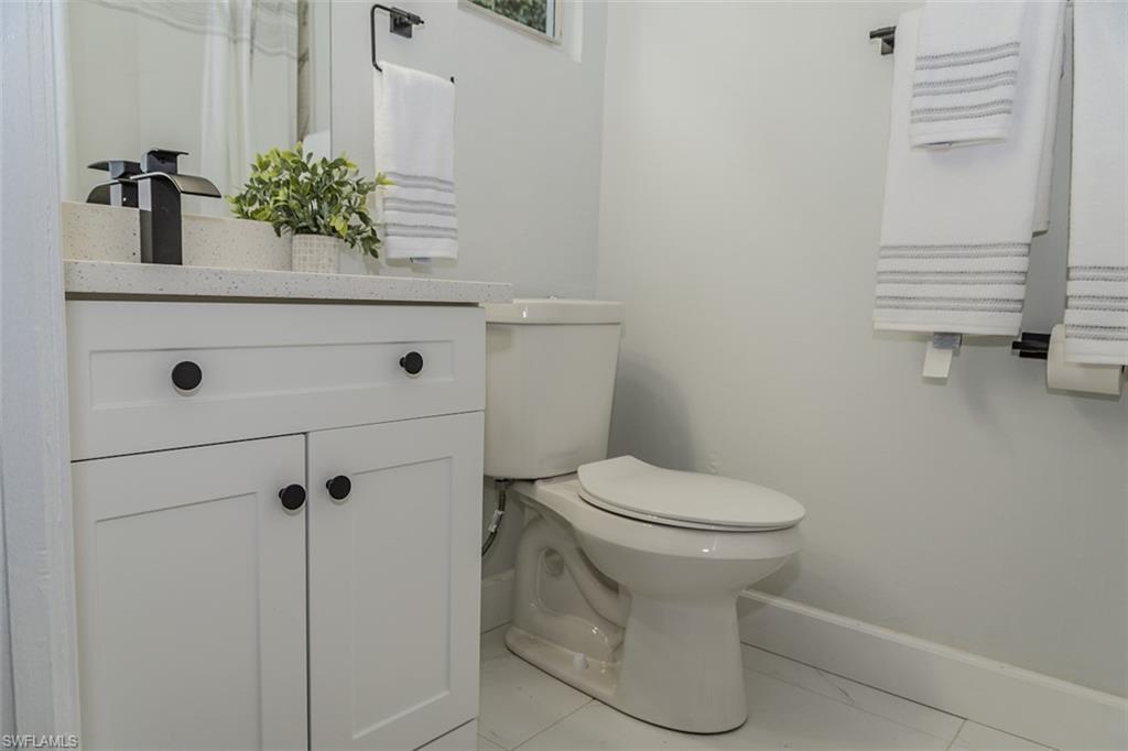 131 22nd Street Northeast Naples, FL 34120 - Photo 22 of 34 a bathroom with a sink a toilet and mirror