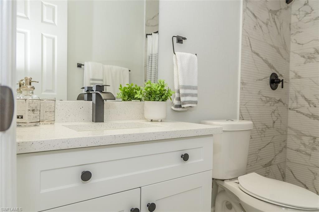 131 22nd Street Northeast Naples, FL 34120 - Photo 27 of 34 a bathroom with a granite countertop toilet sink and mirror