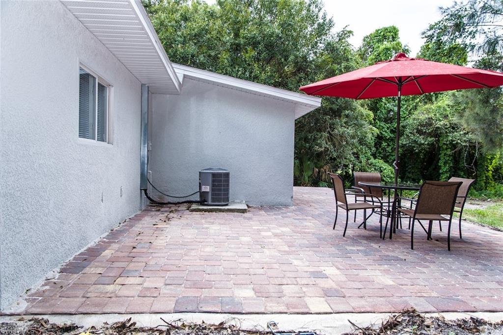 131 22nd Street Northeast Naples, FL 34120 - Photo 33 of 34 a patio with a table and chairs under an umbrella