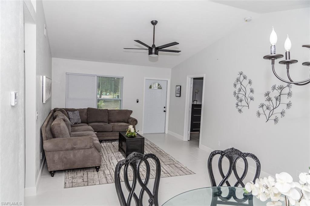 131 22nd Street Northeast Naples, FL 34120 - Photo 8 of 34 a living room with furniture a dining table and a chandelier