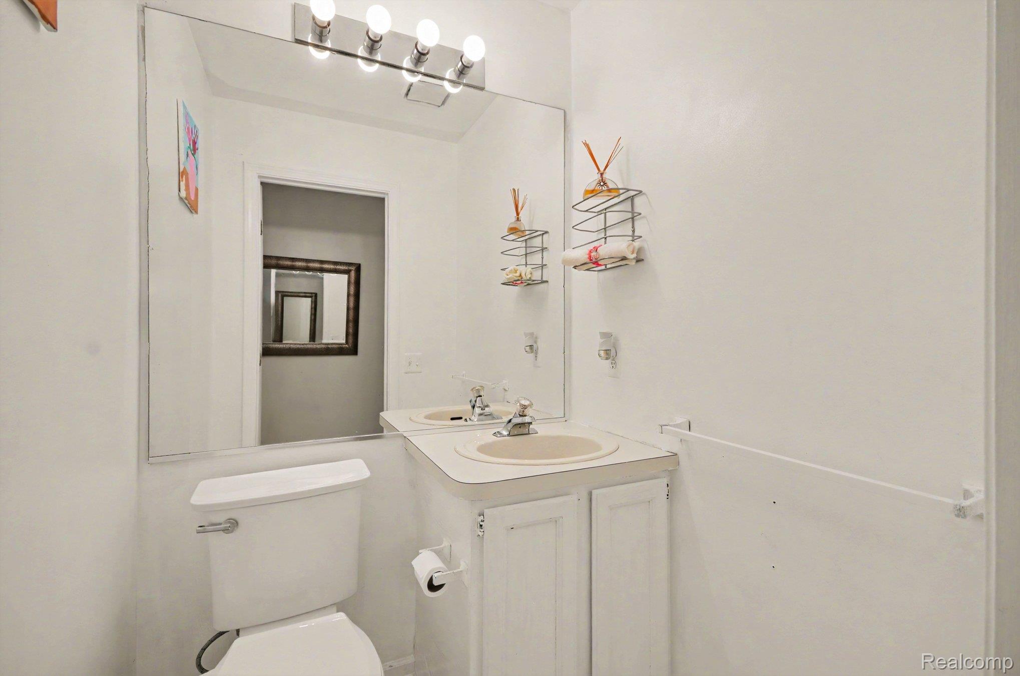 425 Thornridge Court Rochester, MI 48307 - Photo 17 of 35 Bathroom featuring a vanity with an integrated sink, a wall-mounted mirror, and overhead vanity lighting