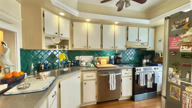 a kitchen with stainless steel appliances granite countertop a sink a stove and cabinets