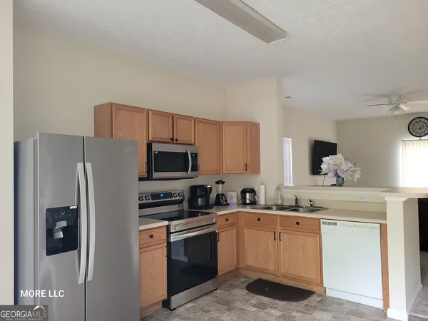 a kitchen with stainless steel appliances a refrigerator stove microwave and sink