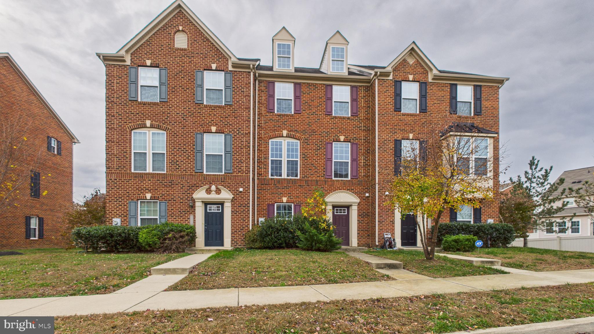 front view of a brick house with a yard