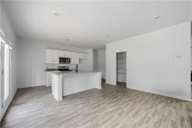 a kitchen with stainless steel appliances granite countertop a sink a stove a refrigerator and cabinets