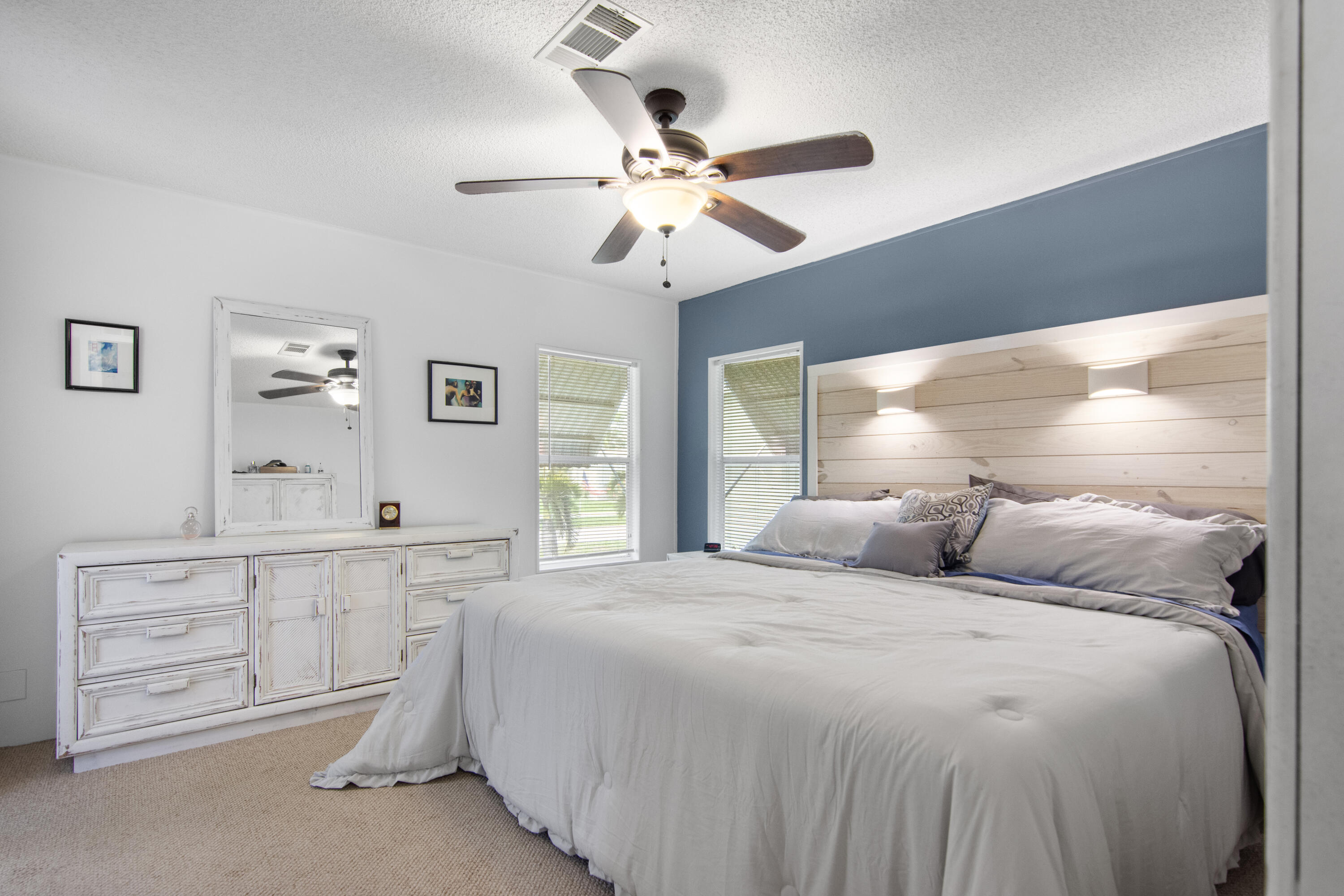 223 Sea Conch Place, Unit 14 Fort Pierce, FL 34982 - Photo 21 of 28 a bedroom with a large bed and a chandelier fan
