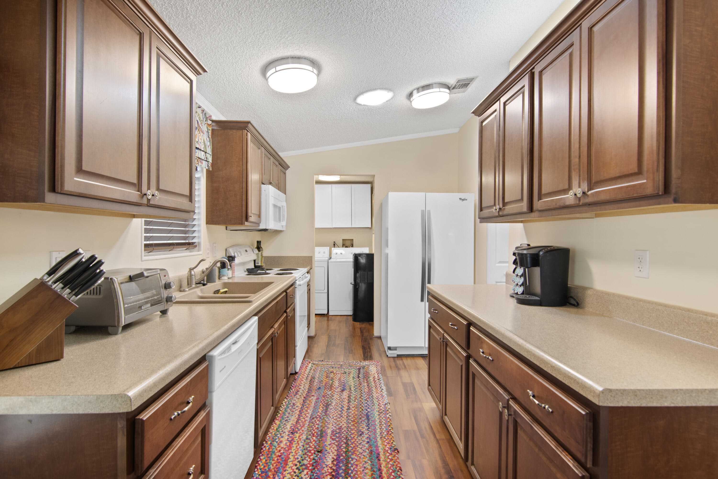 223 Sea Conch Place, Unit 14 Fort Pierce, FL 34982 - Photo 22 of 28 a kitchen with a sink a stove and cabinets