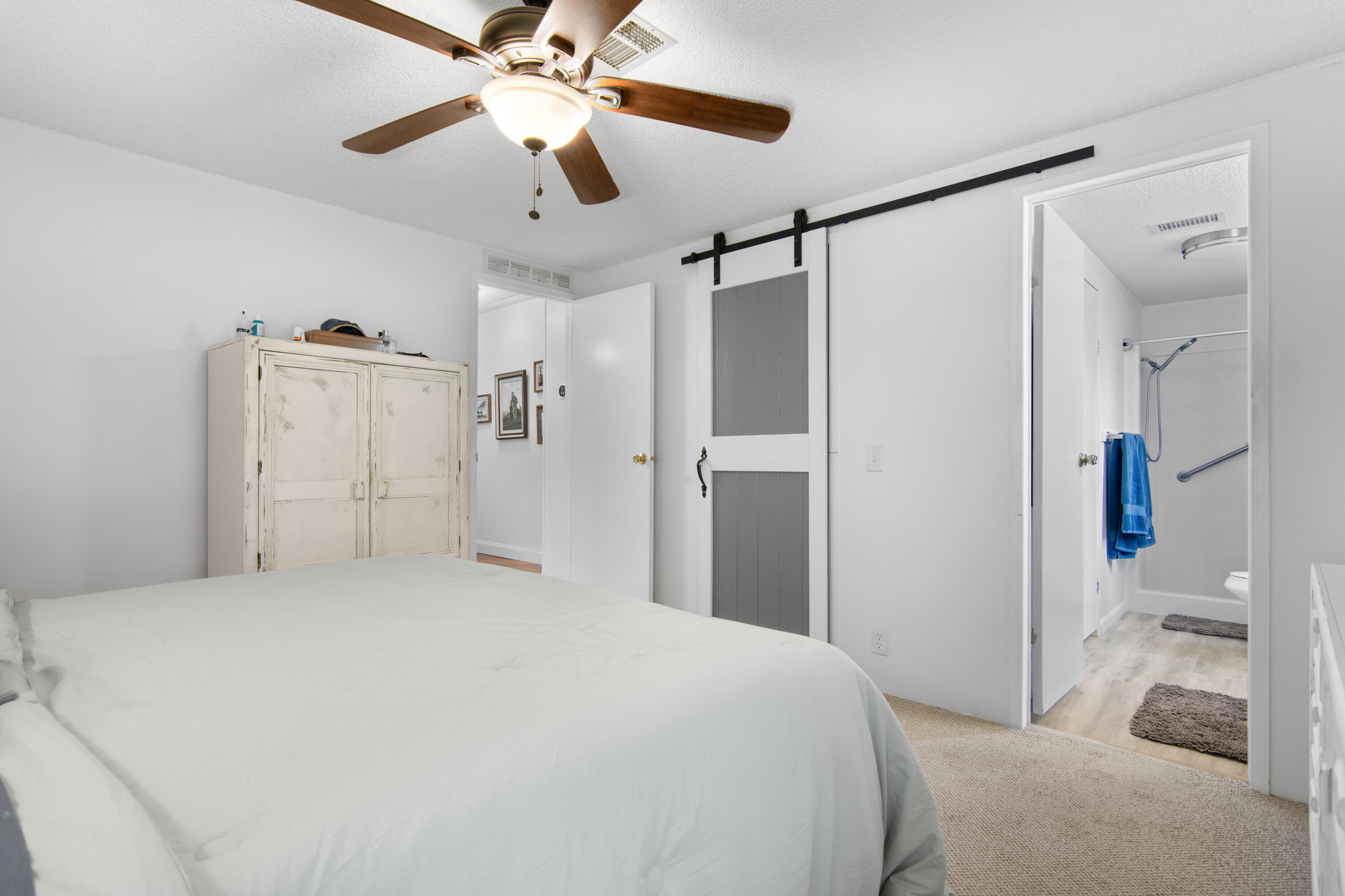 223 Sea Conch Place, Unit 14 Fort Pierce, FL 34982 - Photo 23 of 28 a bedroom with a bed and a chandelier