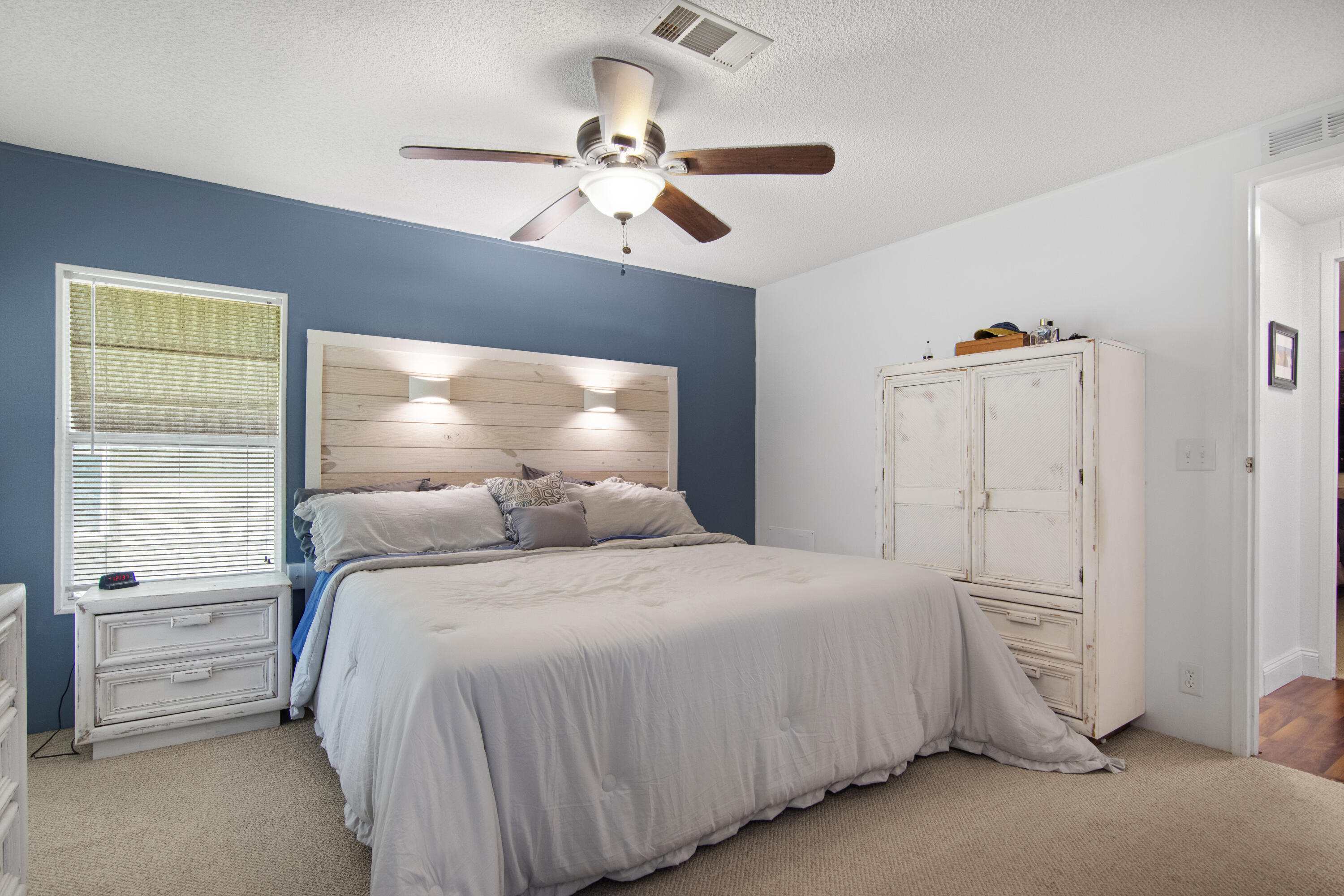 223 Sea Conch Place, Unit 14 Fort Pierce, FL 34982 - Photo 25 of 28 a bedroom with a bed and a chandelier