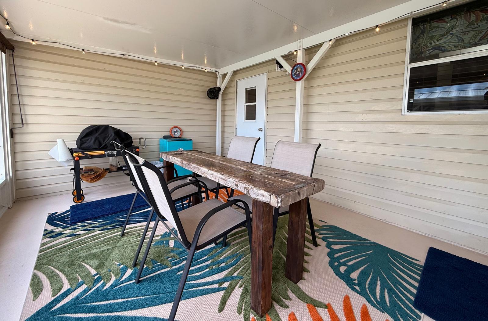 223 Sea Conch Place, Unit 14 Fort Pierce, FL 34982 - Photo 6 of 28 a view of a patio with table and chairs with wooden floor and fence