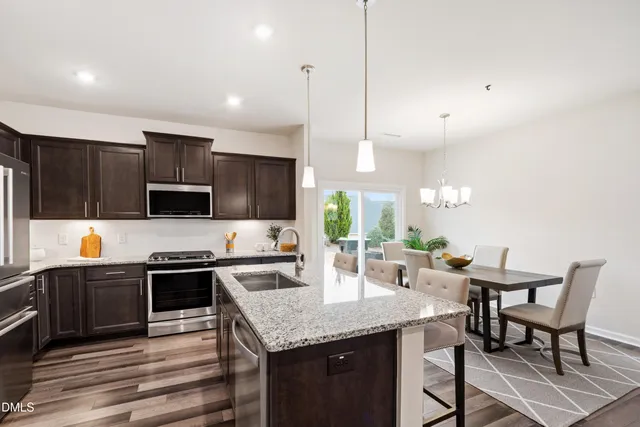 a kitchen with granite countertop a sink and refrigerator