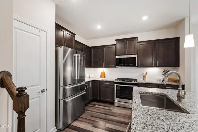 a kitchen with stainless steel appliances granite countertop a kitchen island a stove and a sink