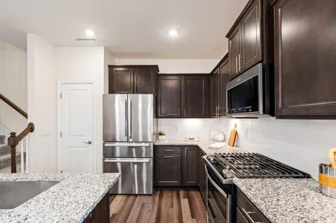 a kitchen with granite countertop a refrigerator and a sink