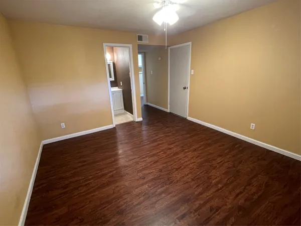 a view of an empty room with wooden floor