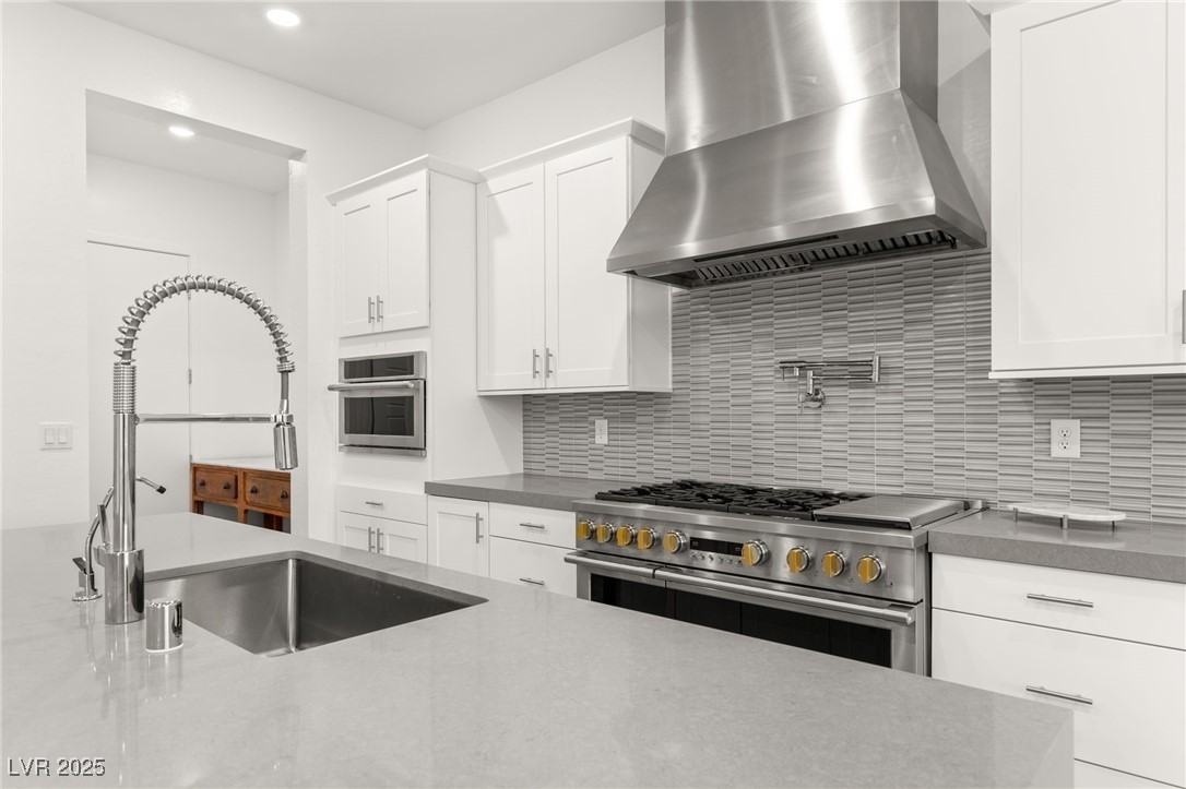 522 Riley Ridge Henderson, NV 89012 - Photo 13 of 53 Kitchen modern backsplash, white cabinetry, appliances with stainless steel finishes