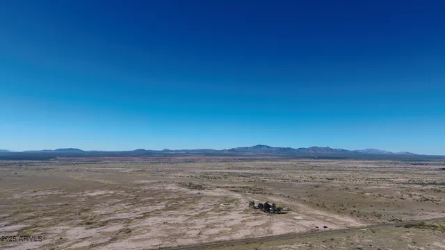 a view of a dry field with wooden fence