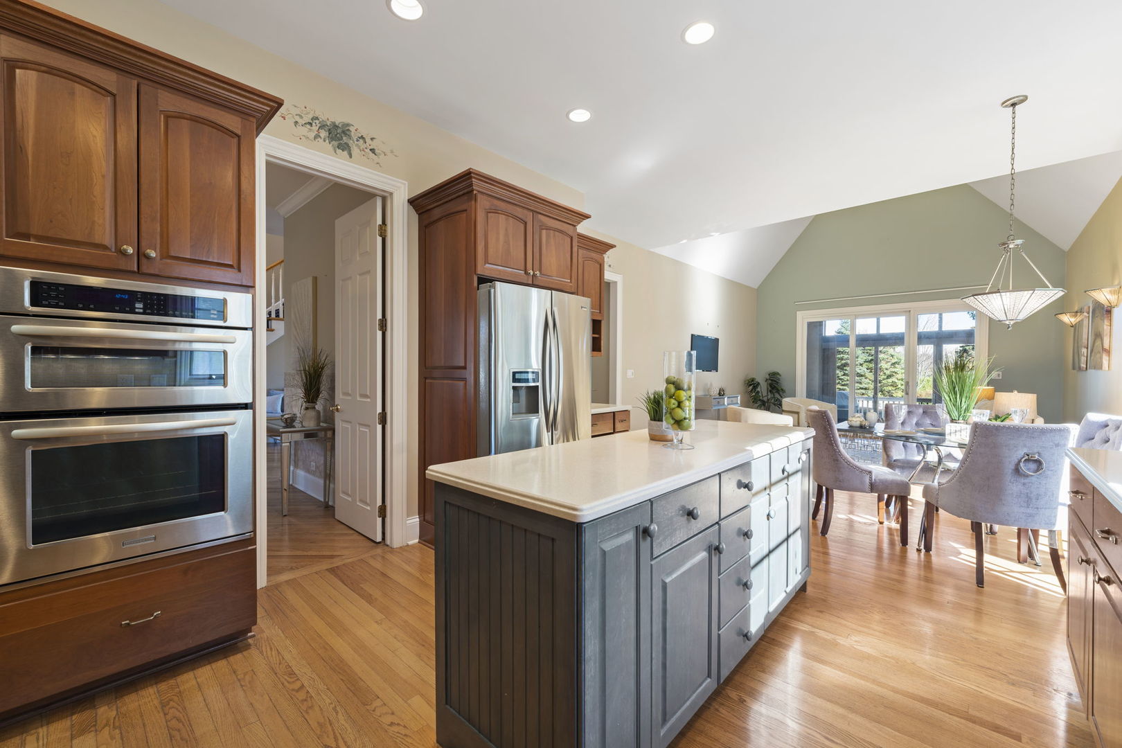 9 Forest Gate Circle Oak Brook, IL 60523 - Photo 19 of 39 a large kitchen with kitchen island a stove a sink a dining table and chairs with wooden floor
