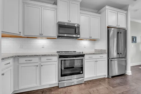 a kitchen with white cabinets and stainless steel appliances