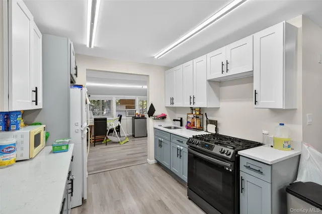 a kitchen with stainless steel appliances a stove a sink and white cabinets