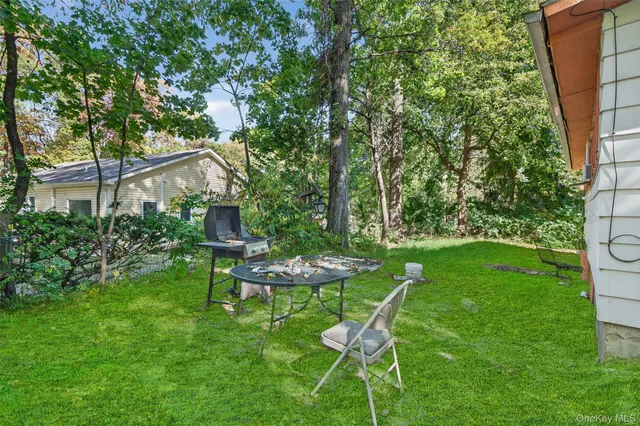 a view of a chair and table in backyard of the house