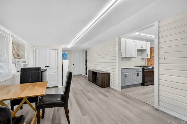 a large white kitchen with stainless steel appliances kitchen island a stove a refrigerator a sink a dining table and chairs