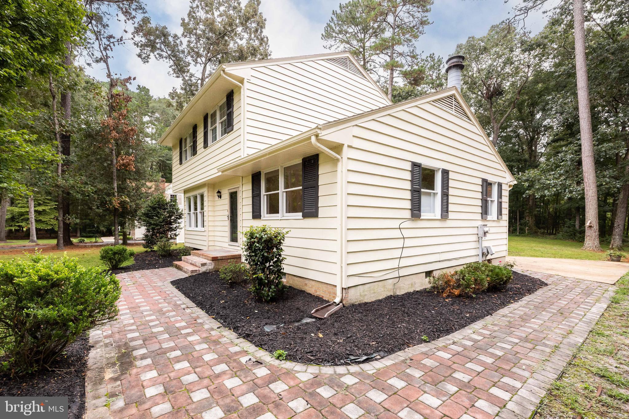 31939 Downing Road Delmar, MD 21875 - Photo 2 of 45 a view of a white house with a yard plants and large tree
