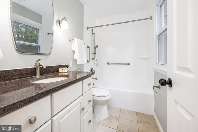 a bathroom with a granite countertop sink toilet and shower