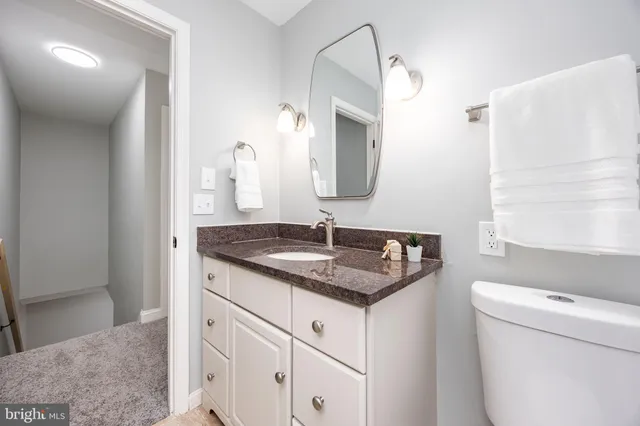 a bathroom with a granite countertop sink and a mirror