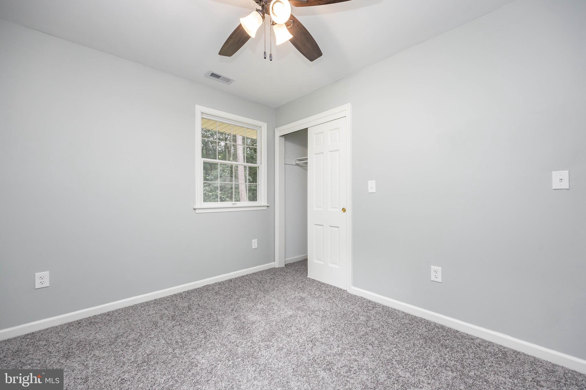 31939 Downing Road Delmar, MD 21875 - Photo 31 of 45 an empty room with a chandelier fan and windows