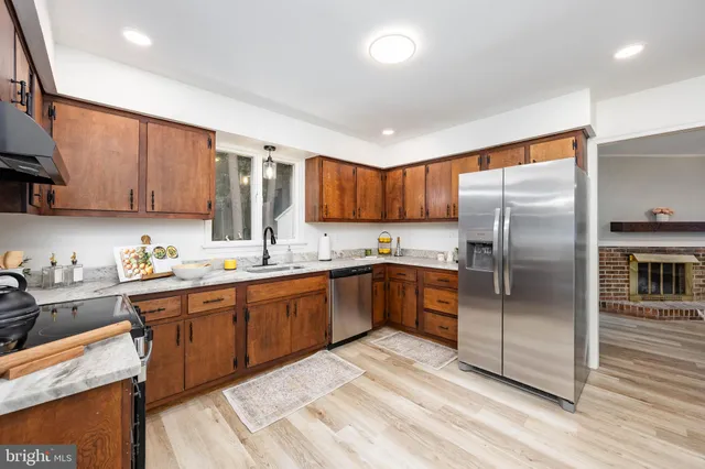 a kitchen with stainless steel appliances granite countertop a refrigerator sink and cabinets