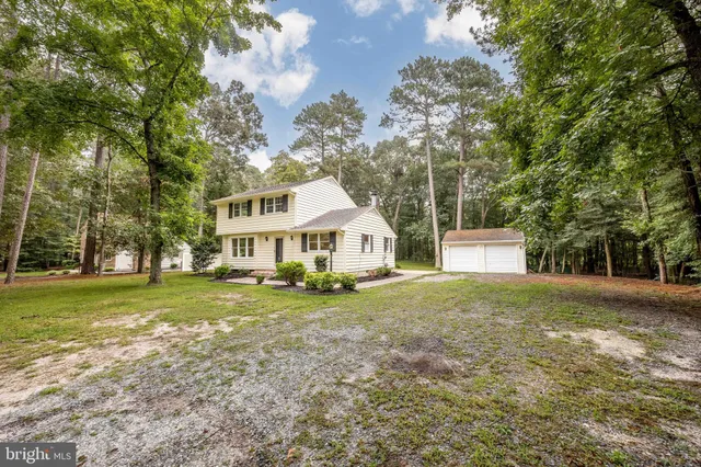 a front view of a house with a yard and trees