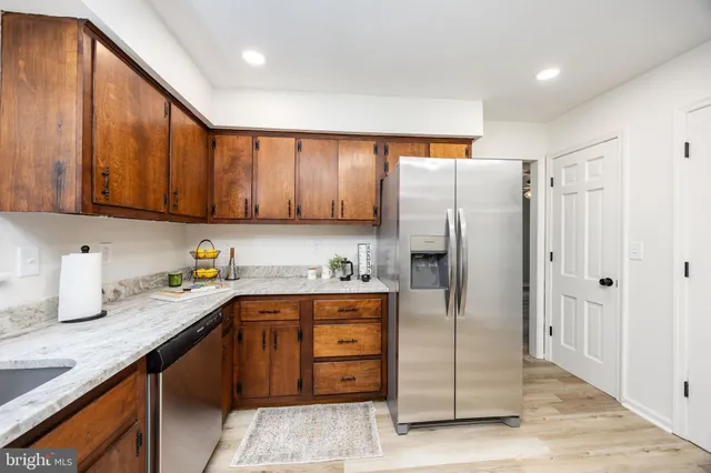a kitchen with stainless steel appliances granite countertop a refrigerator and a sink