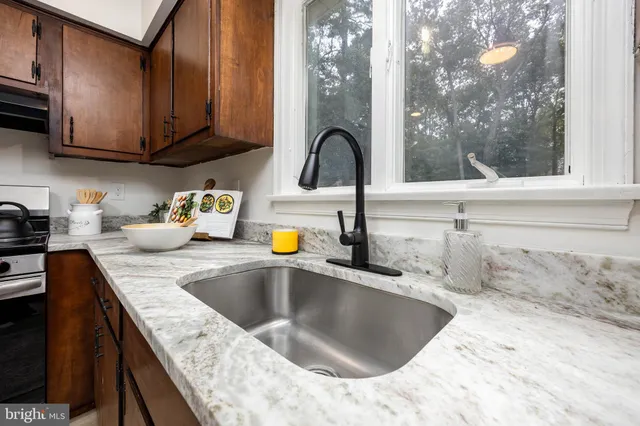 a kitchen with granite countertop a sink and a stove top oven