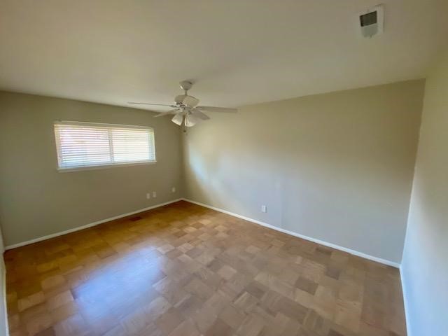 6002 Effingham Drive Houston, TX 77035 - Photo 18 of 22 an empty room with windows and chandelier fan