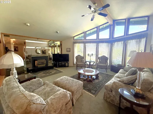 a living room with furniture fireplace and a large window