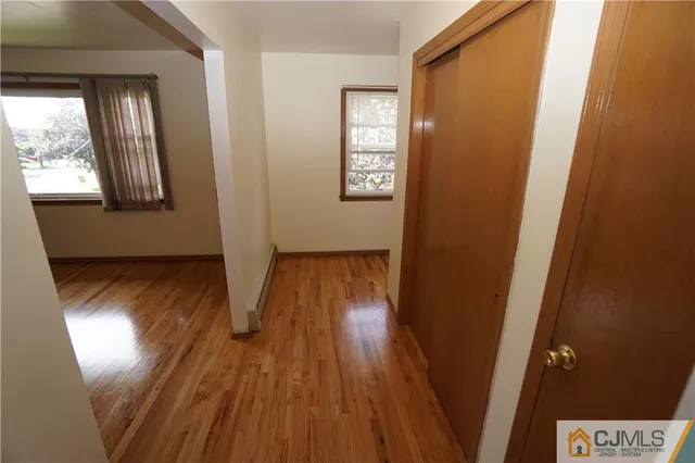 a view of empty room with wooden floor