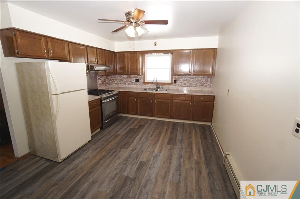 400 Washington Avenue Linden, NJ 07036 - Photo 7 of 18 a kitchen with a refrigerator a sink and dishwasher with wooden floor