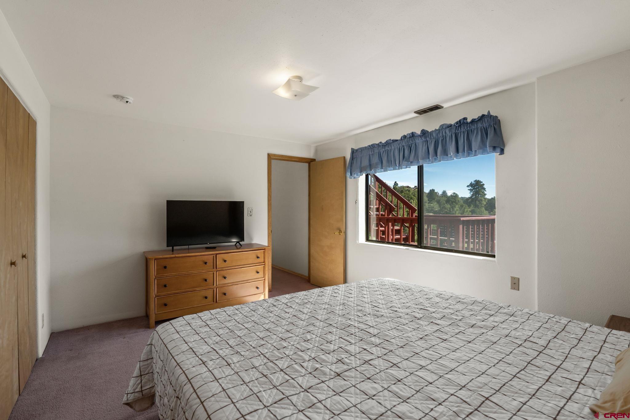 720 Sawmill Road Durango, CO 81303 - Photo 29 of 41 a bedroom with a bed and a flat screen tv