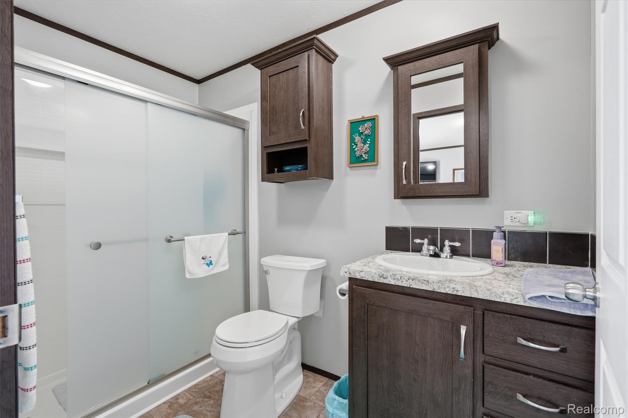 440 Flamingo Street Rochester, MI 48309 - Photo 21 of 32 Bathroom featuring a stall shower, vanity, and crown molding