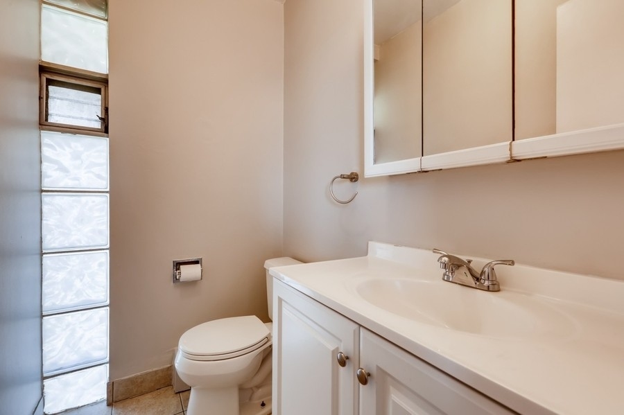 2206 South Goebbert Road, Unit 409 Arlington Heights, IL 60005 - Photo 9 of 10 a bathroom with a sink a toilet and a window