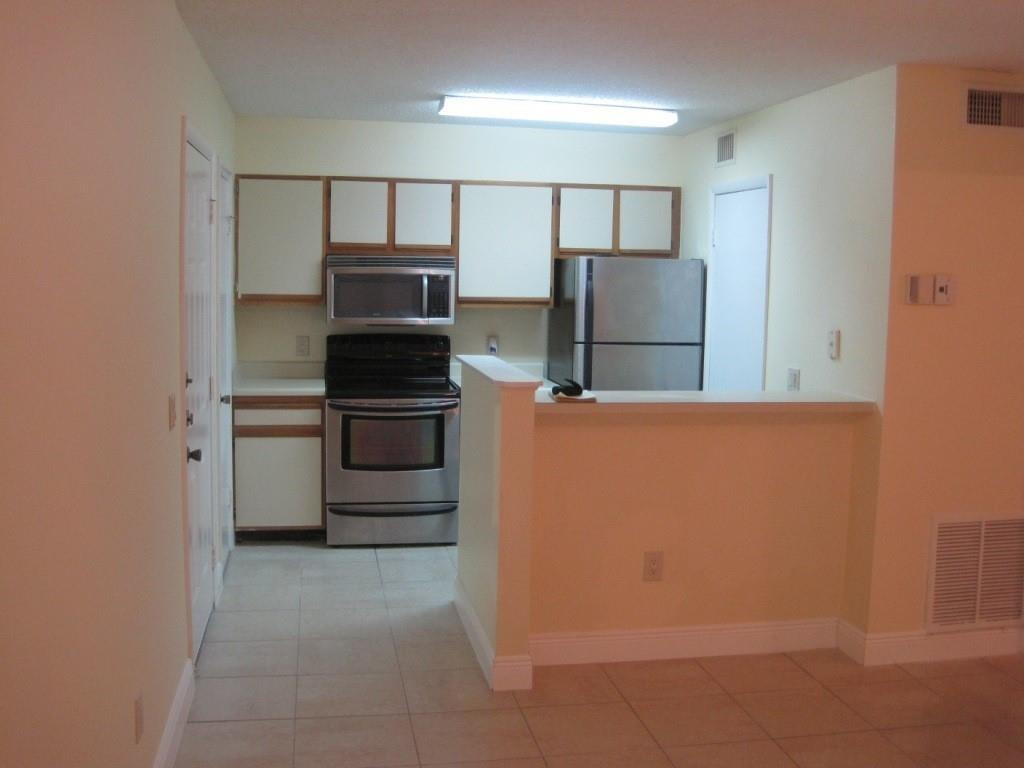 4221 West McNab Road, Unit 29 Pompano Beach, FL 33069 - Photo 3 of 15 a kitchen with stainless steel appliances a refrigerator and a stove