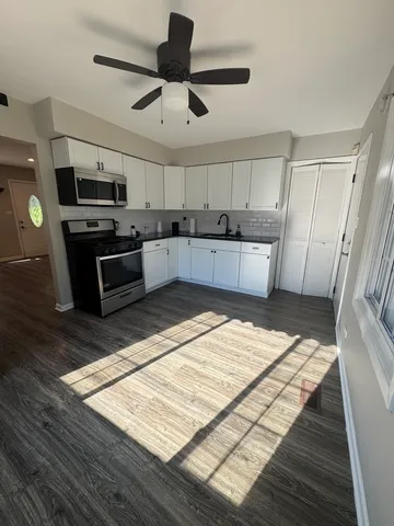 a large kitchen with stainless steel appliances kitchen island granite countertop a table and chairs in it