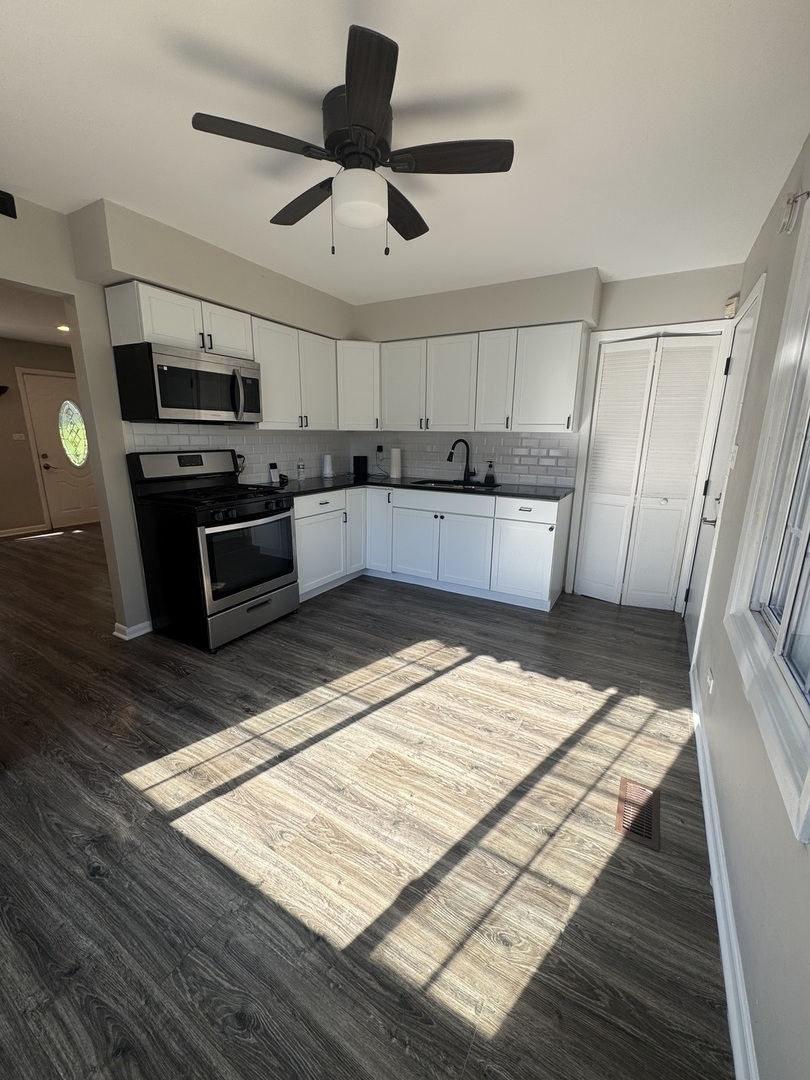 3614 Wheelwood Court Hazel Crest, IL 60429 - Photo 3 of 9 a large kitchen with stainless steel appliances kitchen island granite countertop a table and chairs in it