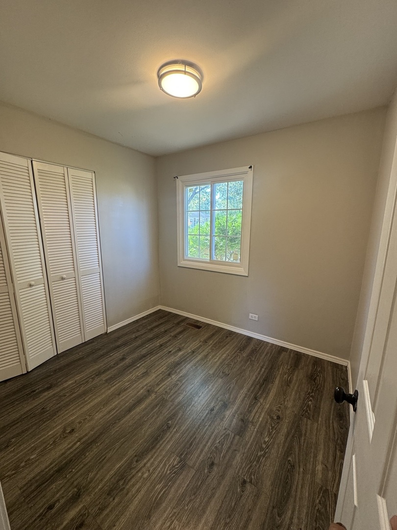 3614 Wheelwood Court Hazel Crest, IL 60429 - Photo 4 of 9 an empty room with wooden floor and windows