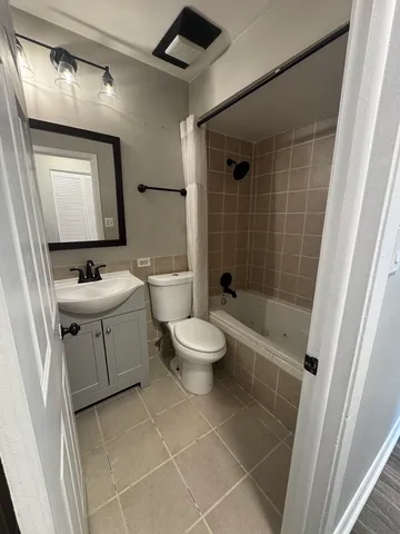 a bathroom with a toilet a sink a mirror and shower