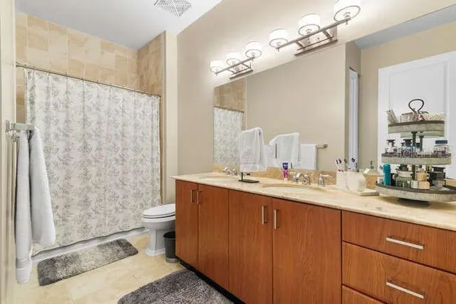 a bathroom with a granite countertop sink and a mirror with toilet